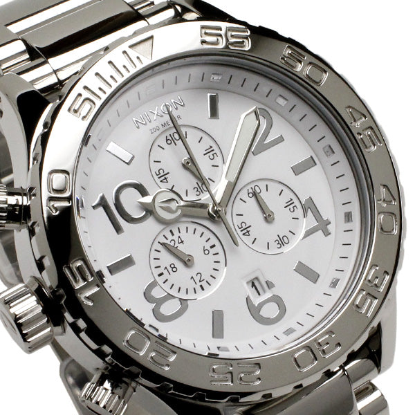 Angled view of white dial with large numerals, chronograph subdials, and bezel markings
