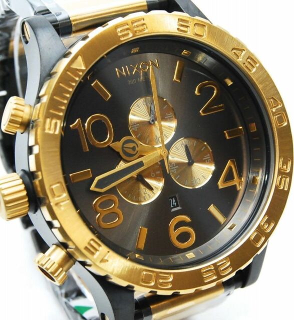 Close-up of black dial with gold chronograph subdials and numerals on Nixon 51-30 watch