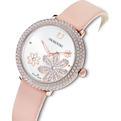 Swarovski Crystal Frost women's watch worn on wrist displaying white dial with floral design and pink strap