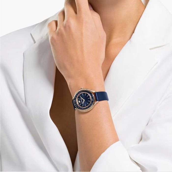 Crystalline Aura rose gold watch on wrist with navy strap