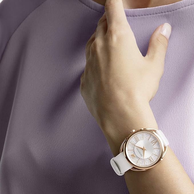 Crystalline Glam watch worn on wrist with white dial and rose gold case against lavender clothing
