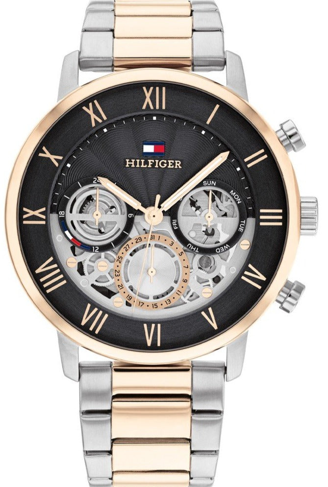 Tommy Hilfiger Legend watch front view with grey dial, skeleton chronograph display, two-tone stainless steel bracelet