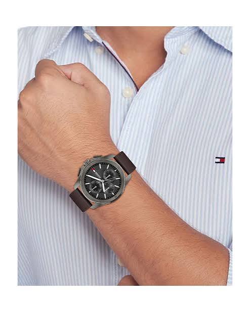 Tommy Hilfiger chronograph watch with grey dial and brown leather strap worn on wrist
