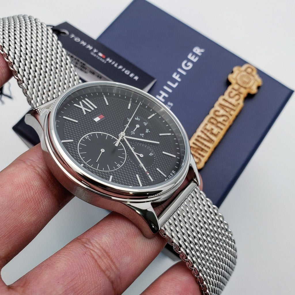 Tommy Hilfiger mesh watch worn on wrist next to product box and documentation