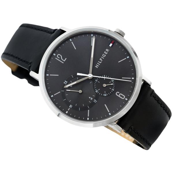 Tommy Hilfiger watch from angled view showing black dial, silver case, and tan-lined black leather strap