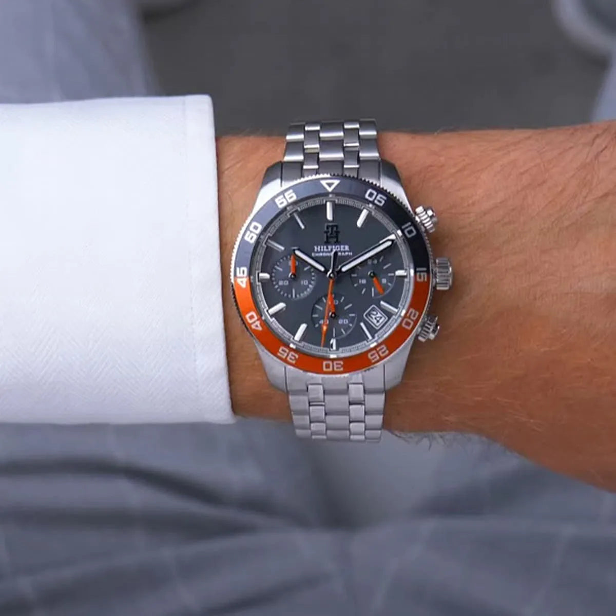 Tommy Hilfiger 1792186 chronograph watch worn on wrist with orange bezel and grey dial