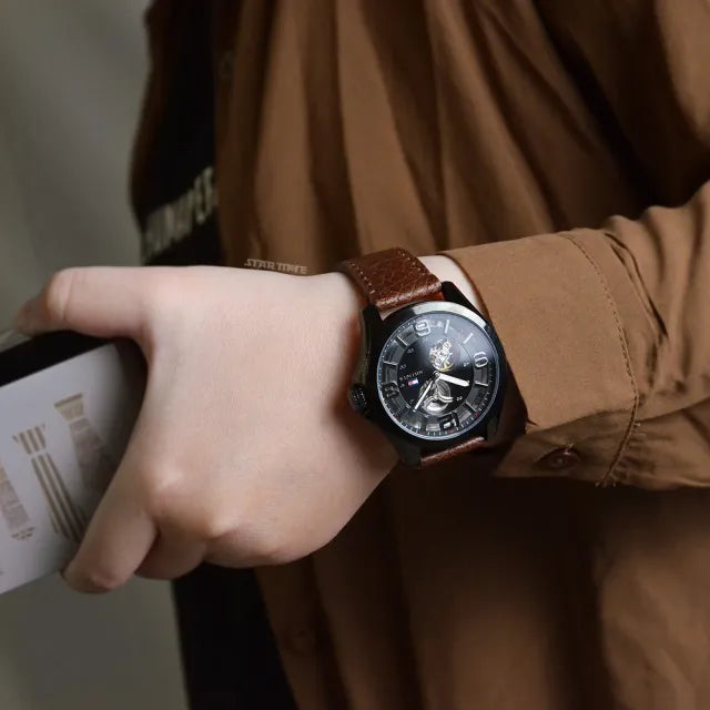 Tommy Hilfiger Bruce watch on wrist showing black dial and brown leather strap styling