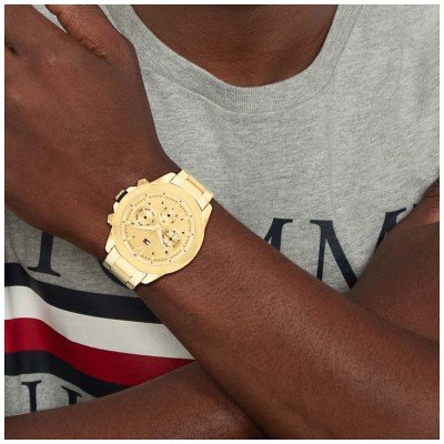 Tommy Hilfiger Lars gold watch worn on wrist with Tommy flag strap visible