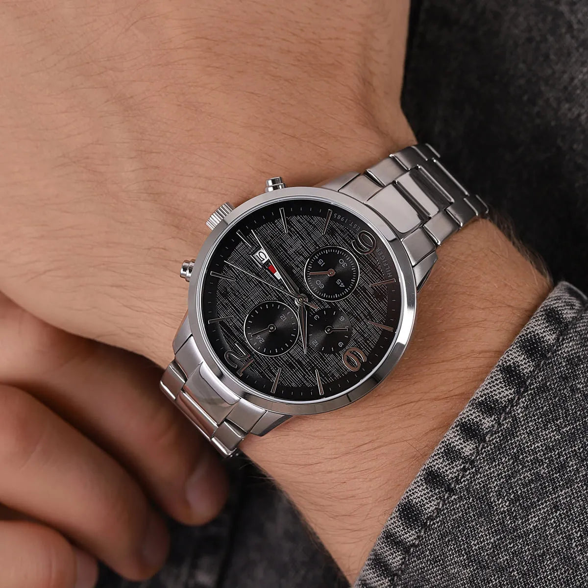 Close-up of Tommy Hilfiger Liam men's watch on wrist showing black dial and chronograph subdials