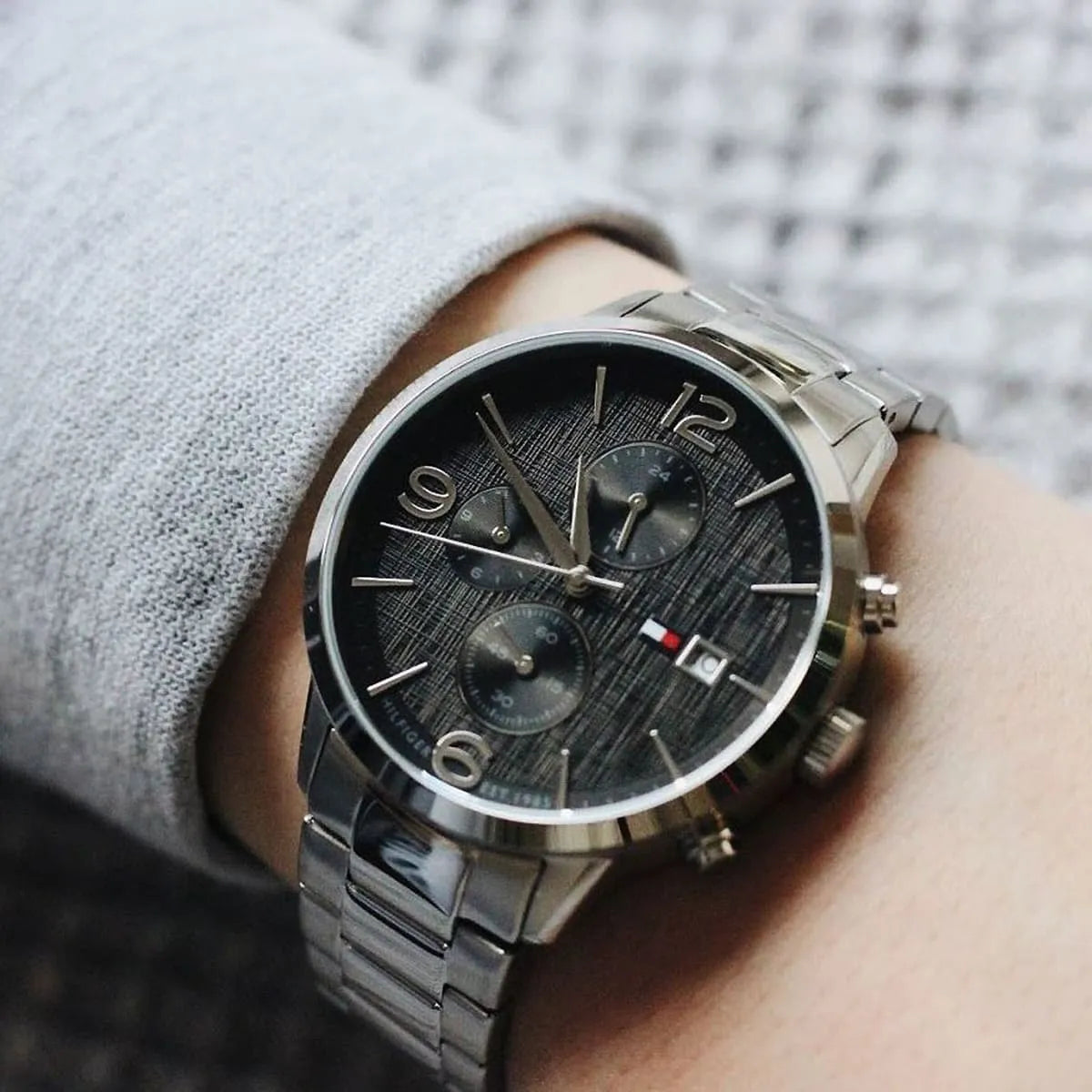 Tommy Hilfiger Liam chronograph watch worn on wrist with black dial and silver bracelet