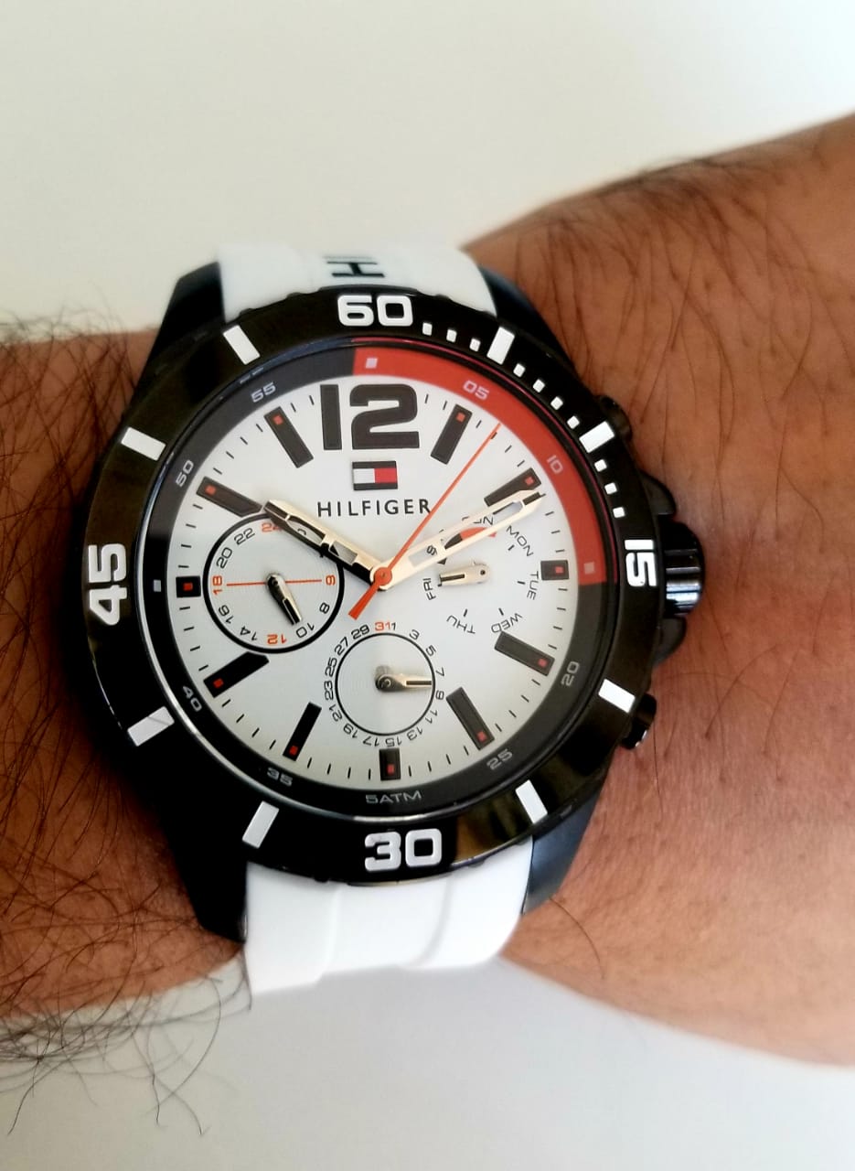 Tommy Hilfiger Nolan chronograph watch worn on wrist with white strap and black bezel