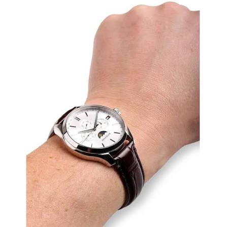 Tommy Hilfiger Oliver watch worn on wrist displaying white dial with moon phase complication