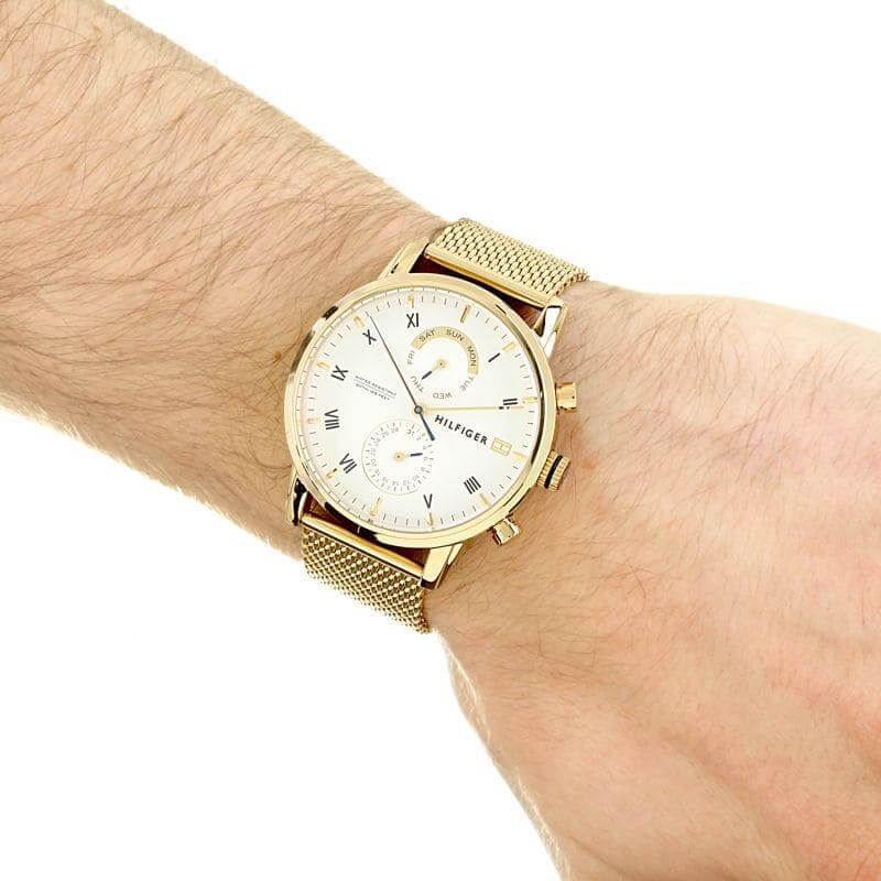 Tommy Hilfiger gold watch with Roman numerals worn on wrist