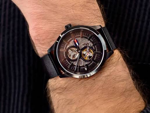 Tommy Hilfiger Spencer skeleton watch worn on wrist with black mesh bracelet