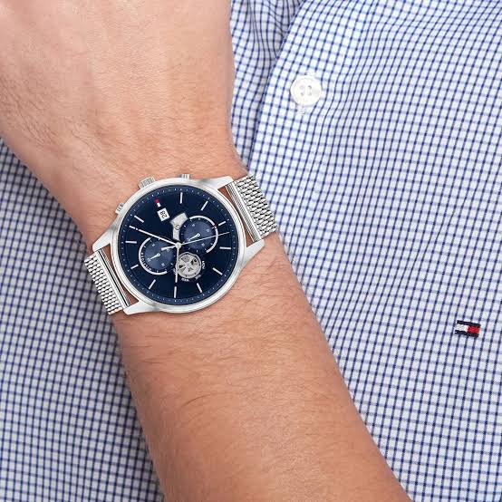 Tommy Hilfiger Weston watch worn on wrist with blue dial and stainless steel mesh strap