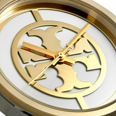 Close-up of Tory Burch The Reva dial with signature Reva logo, gold hands, and markers