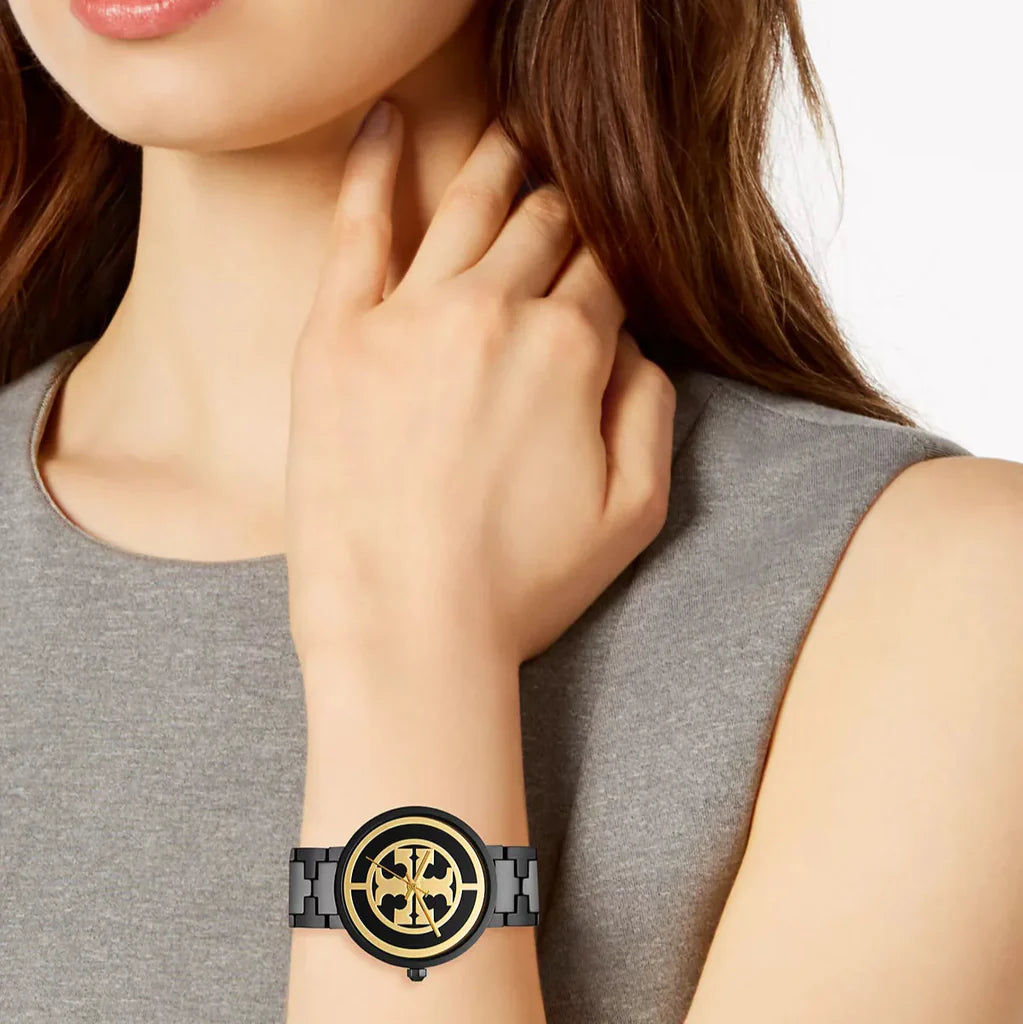 Tory Burch Reva watch on wrist worn by woman with black dial and gold accents