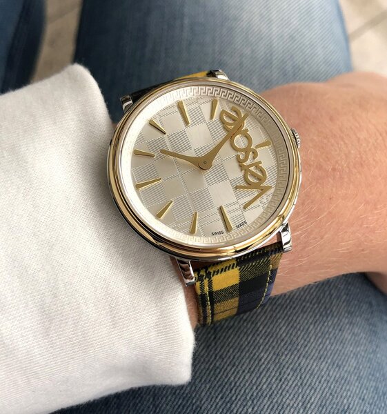Versace V-Race 46MM worn on wrist with plaid fabric strap and cream dial visible