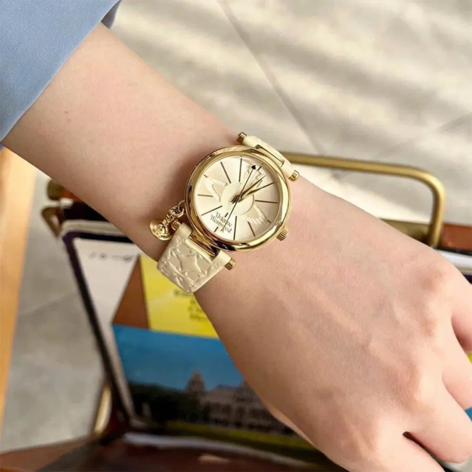 Vivienne Westwood Orb II watch worn on wrist with white leather strap and gold case