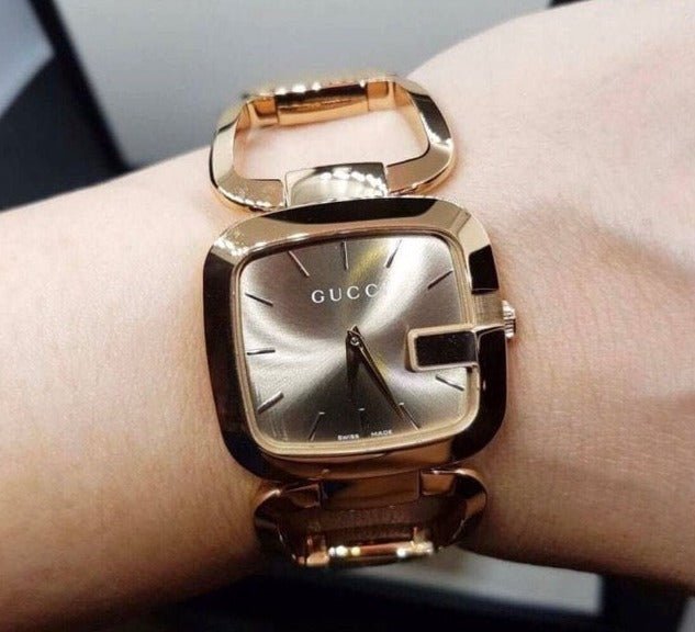 Gucci YA125408 gold watch on wrist showing grey dial and gold bracelet