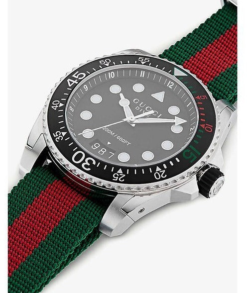 Angled view of Gucci Dive watch with red and green striped strap and silver case